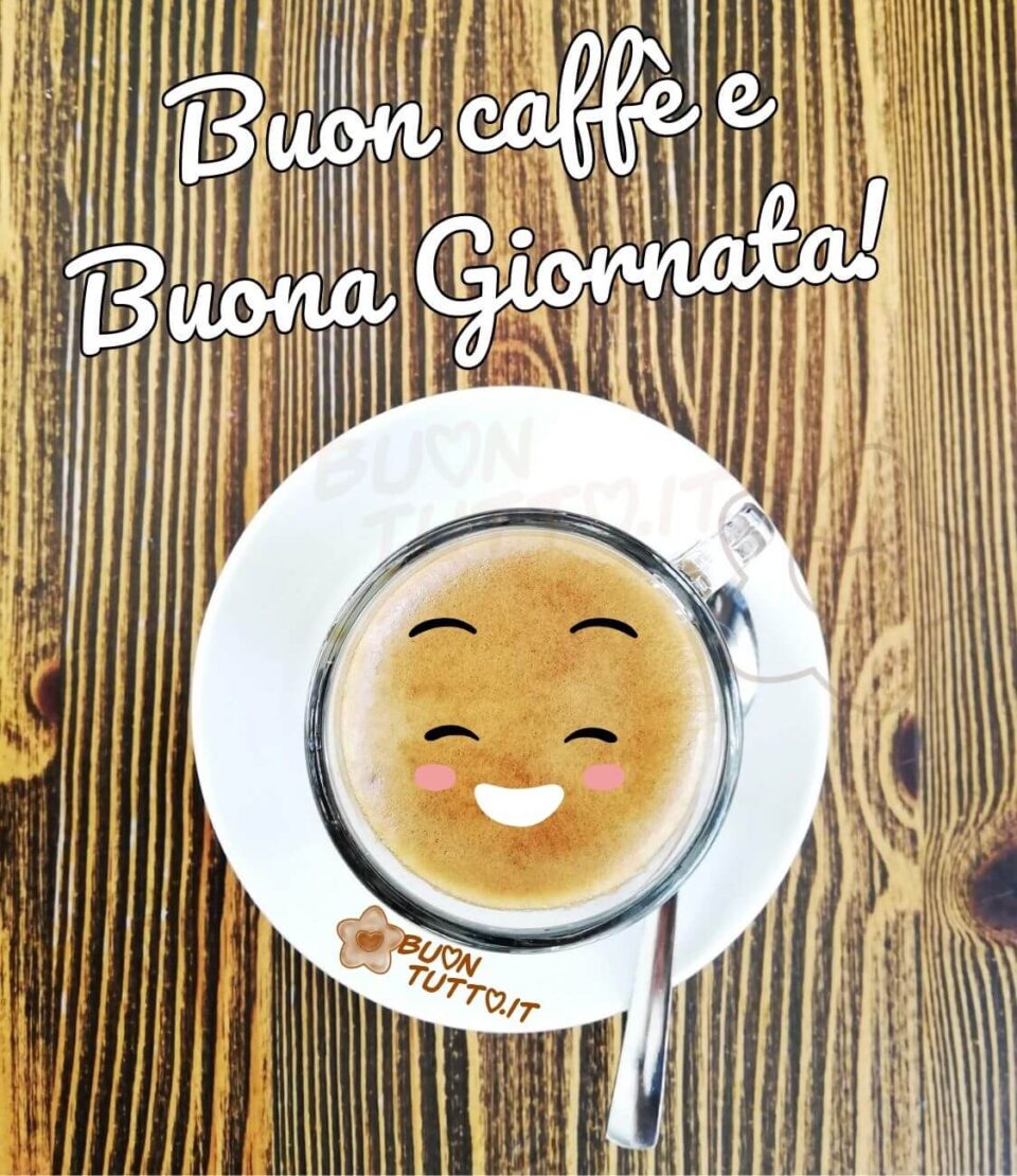immagini-buongiorno-buon-caffè-buona-giornata-dolcissima-faccina-sorridente-buontutto Foto di una tazzina di caffè di vetro con piattino di ceramica e cucchiaino di acciaio in stile moderno appoggiata su un tavolo di legno chiaro con venature, sopra la cremina del caffè c'è disegnata una simpatica faccina con un sorriso gioviale e delle dolcissime guancette rosa. Nella parte alta dell'immagine c'è scritto in un carattere corsivo buon caffè e buona giornata con un punto esclamativo di colore bianco e contorno nero. Un'immagine che trasmette gioia e ottimismo. Una raccolta di nuove bellissime Immagini di Buongiorno con caffè da scaricare gratis e condividere con amici parenti gruppi tramite WhatsApp Facebook Twitter Pinterest Telegram Instagram autore buontutto.it