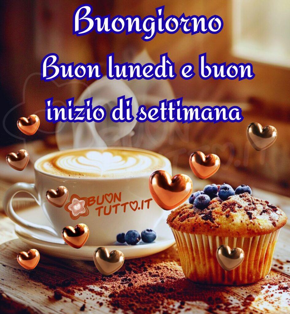 Foto di una golosa, accogliente e appetitosa colazione con una tazza di cappuccino e un muffin ai mirtilli su un tavolo di legno. La tazza di cappuccino, bianca e su un piattino dello stesso colore. Si vede un po' di vapore che si alza dalla bevanda, indicando che è calda. Sulla schiuma del cappuccino, con la tecnica del latte-art, è stata disegnata una forma di cuore. Accanto alla tazza, c'è un muffin dorato, la cui superficie è generosamente ricoperta di mirtilli freschi. Sul tavolo, cosparso di polvere di cacao, si vedono anche alcuni mirtilli sparsi. Intorno agli elementi principali, fluttuano diversi cuori lucidi e tridimensionali in una tonalità dorata/bronzea, che amplificano l'atmosfera affettuosa e sognante dell'immagine. La luce è soffusa e calda. Nella parte alta dell'immagine c'è scritto in un carattere corsivo elegante con ghirigori di colore bianco e contorno azzurro marcato Buongiorno Buon lunedì e buon inizio di settimana. Un'immagine che trasmette pace, accoglienza, affetto, bellezza e tanta serenità da scaricare gratis e condividere con amici, cari, familiari, parenti gruppi tramite WhatsApp, Facebook, X Twitter, Pinterest, Telegram, LinkedIn, Instagram e le tue piattaforme social preferite. Autore BuonTutto.it